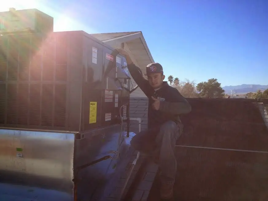 HVAC technician performing Air Duct Cleaning on a rooftop unit in Fairview Heights